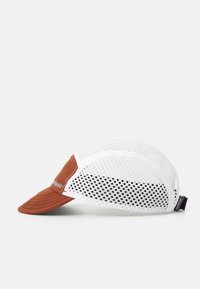 Brun og hvid mesh baseball cap med buet skygge og justerbar bagrem, lagt på en hvid overflade, set fra siden med mærkelabel.