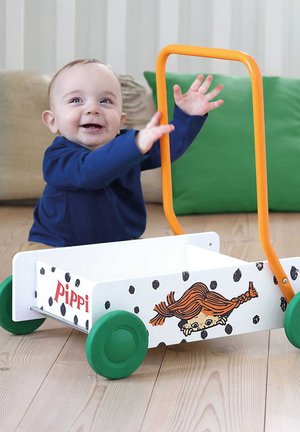 Carrello giocattolo in legno con corpo bianco, punti neri, ruote verdi e manico arancione, caratterizzato da un design di un personaggio con capelli arancioni.