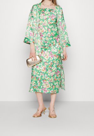 Sukienka w kwiaty i dopasowany kimono w zielonym kolorze, z różowymi i białymi kwiatami, złotą kopertówką i sandałami na cienkim obcasie. Gładki materiał, długość do kolan.