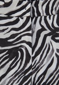 Zebraprint stof met gedurfde zwart-witte strepen, met een gladde textuur en een platte tailleband.