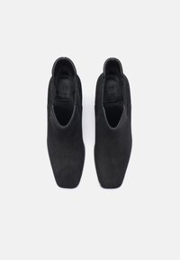 Sorte semskede ankelstøvler med spiss tå-design, som har elastiske sidepaneler og en jevn indre fôring. Minimalistisk og slank form.