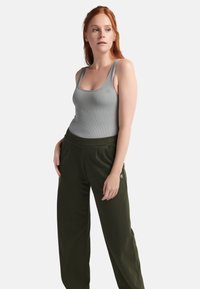 Grijze geribbelde tanktop met brede banden, gecombineerd met olijfgroene, relaxed-fit broek met zijzakken en een klein logo op het been.