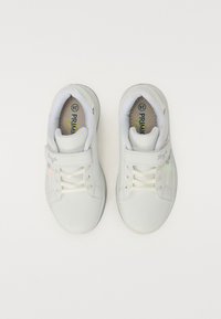 Hvide sneakers med en glat finish, snøre- og velcro-lukning, polstret tunge, let buet form og en subtil stjerneaccent på siden.