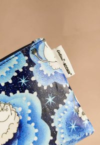 Tõmblukuga kotike, mille välisküljel on sinine ja must pilvemuster, multikategelased ning valge silt, millel on kiri "Moomin."