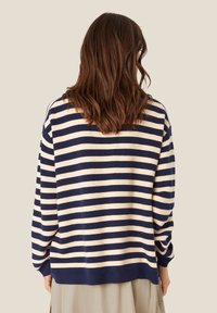 Gestreifter Strickpullover in Marineblau und Creme, mit lässiger Passform, langen Ärmeln und abgerundetem Saum. Strukturierter Stoff mit weicher Oberfläche.