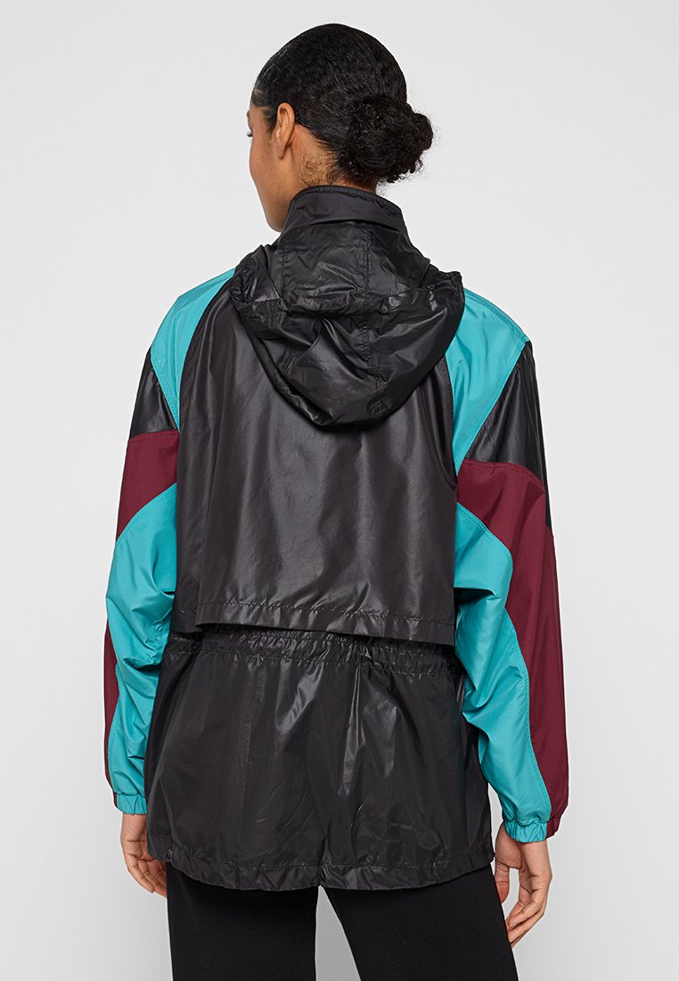 Kurtka przeciwdeszczowa w kolorach blokowych, z czarną bazą oraz akcentami w kolorze turkusowym i bordowym. Posiada kaptur, elastyczne mankiety i ściągniętą talię.