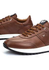 Brown leather sneakers with brown laces, white midsoles, black outsoles, and a small white "W" logo on the side and tongue.