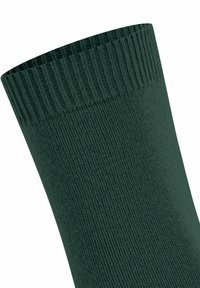 Primo piano di una calza di colore verde scuro con risvolto a coste e trama fine.