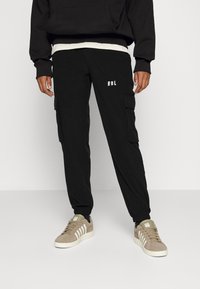 Redefined Rebel ARCHER PANTS UNISEX  - Calças de fato de treino - black