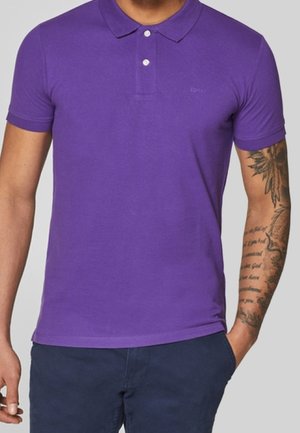 Polo shirt in solid purple, made of cotton, featuring a classic collar, three-button placket, short sleeves, and subtle branding.