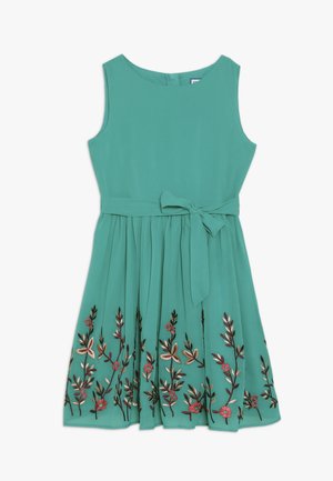 Ærmeløs teal kjole med bundet bånd i taljen og blomsterbroderi langs nederdelen af skørtet.