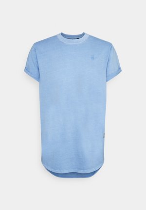 Heled sinine T-särk ümmarguse kaelusega, lühikeste rullitud varrukatega ja veidi kaarduva hemiga. Valmistatud pehmest, tekstureeritud kangast. Eesmise poolel väike logo detail.