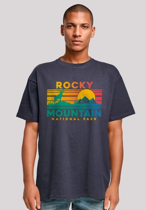 Navy blue cotton t-shirt featuring a retro graphic in yellow, orange, green, and blue, showcasing “Rocky Mountain National Park” and a silhouette of a deer.