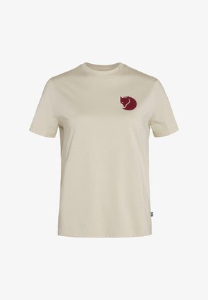 Camiseta crema de algodón con mangas cortas. Presenta un logo de zorro burdeos en el lado izquierdo del pecho. Corte estándar y textura suave.