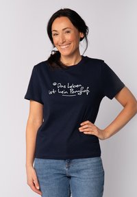 T-shirt en coton bleu marine avec un texte blanc qui dit "Das Leben ist kein Ponyhof." Manches courtes et col rond classique.