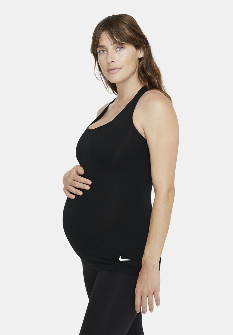 Fekete sportos ujjatlan felső rugalmas anyagból, mély dekoltázzsal és karcsú szabással, az alján egy kis fehér Nike logóval.