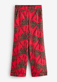 Punased püksid, millel on julge leopardimuster ja suurte mustade paeltega dekoratsioon. Elastne vöökoht ja lai lõige pahkluude juures.