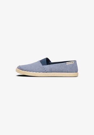 Chaussure slip-on en toile rayée bleu et blanc avec une semelle en caoutchouc et un bord en jute. Présente un bout arrondi et des panneaux élastiques sur les côtés pour un enfilage facile.