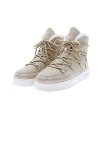 Zapatillas altas beige con forro de piel sintética, cordones planos, acentos metálicos y parte superior texturizada sobre una suela de goma blanca.