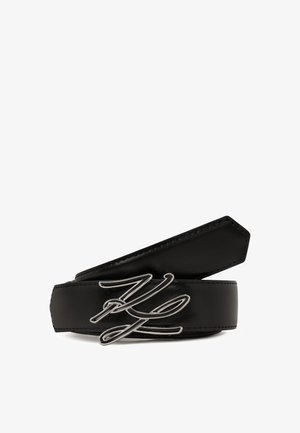 Black leather belt with a silver abstract buckle, featuring smooth texture and clean edges. Designed with a stitched border for durability.