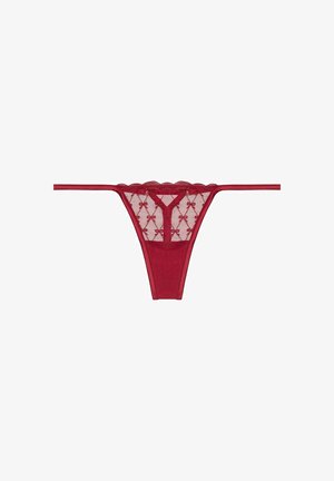 Red lace thong with scalloped edges, featuring sheer fabric and a decorative bow pattern. Thin side straps and lined back.