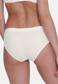 Crème-kleurige katoenen slips met een middelhoge tailleband en een gladde, naadloze textuur, met subtiele logodetails op de tailleband.