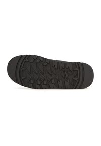 Suela de zapato de goma negra con una superficie texturizada que presenta patrones triangulares y angulares para mejorar el agarre y la tracción.