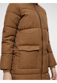 Brun pufferjakke med lynlås foran, med vandret quiltede sektioner og en frontlomme. Glat tekstur og afslappet pasform.