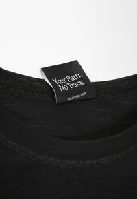 Zwart T-shirt met een ronde halslijn; label met witte tekst waarop staat "Your Path, No Trace." van nnormal.com. Zachte stoftextuur.