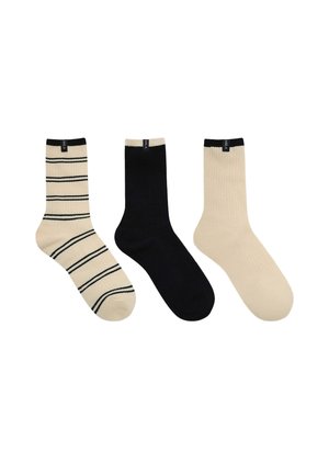 Trois chaussettes mi-mollet présentées côte à côte : beige avec des rayures noires, noir uni, et beige uni, chacune avec une petite étiquette noire en haut.