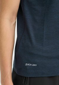 Námořnicky modré sportovní tričko s textem pro rychlé schnutí, s hladkým povrchem a krátkými rukávy. Č stitching viditelné podél bočních švů.