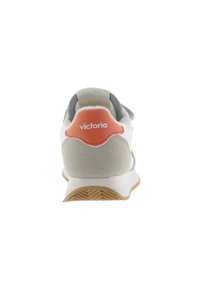 Zapatilla blanca y gris con un talón texturizado y un logotipo naranja. Cuenta con un material suave similar al ante y una suela de goma flexible.
