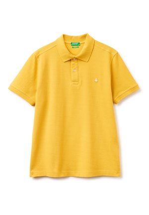 Polo amarillo de manga corta con dos botones y un pequeño logo bordado en el pecho izquierdo sobre fondo blanco.