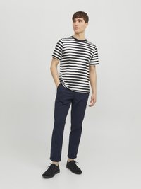 Gestreiftes kurzärmliges T-Shirt in Marineblau und Weiß, kombiniert mit marineblauen Slim-Fit-Hosen und schwarzen Schuhen. Einfaches Design, lässige Kleidung.