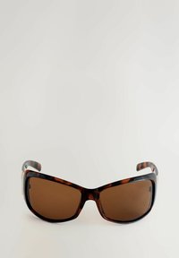 Brūnas nokrāsas saulesbrilles ar čūskas čaulām rakstu. Lielizmēra ietvars ar gludām malām un strukturētiem kājiņām. Zelta akcenti uz sāniem.