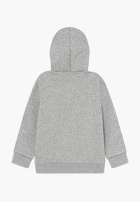 Grijze katoenen hoodie, zachte textuur, met kangoeroezakken, elastische manchetten en een capuchon met koordje. Eenvoudig ontwerp zonder zichtbare branding.