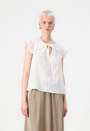 Hvit, lett bluse med en nøkkelhulls knyting, volange korte ermer og vertikale striper, parret med et plissébeige skjørt.