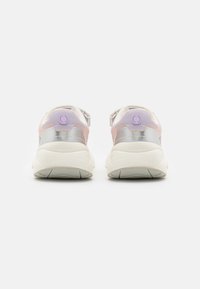 Vista trasera de zapatillas que presentan una combinación de materiales en blanco, plata y lavanda, con una suela texturizada y detalles de marca redondeados.