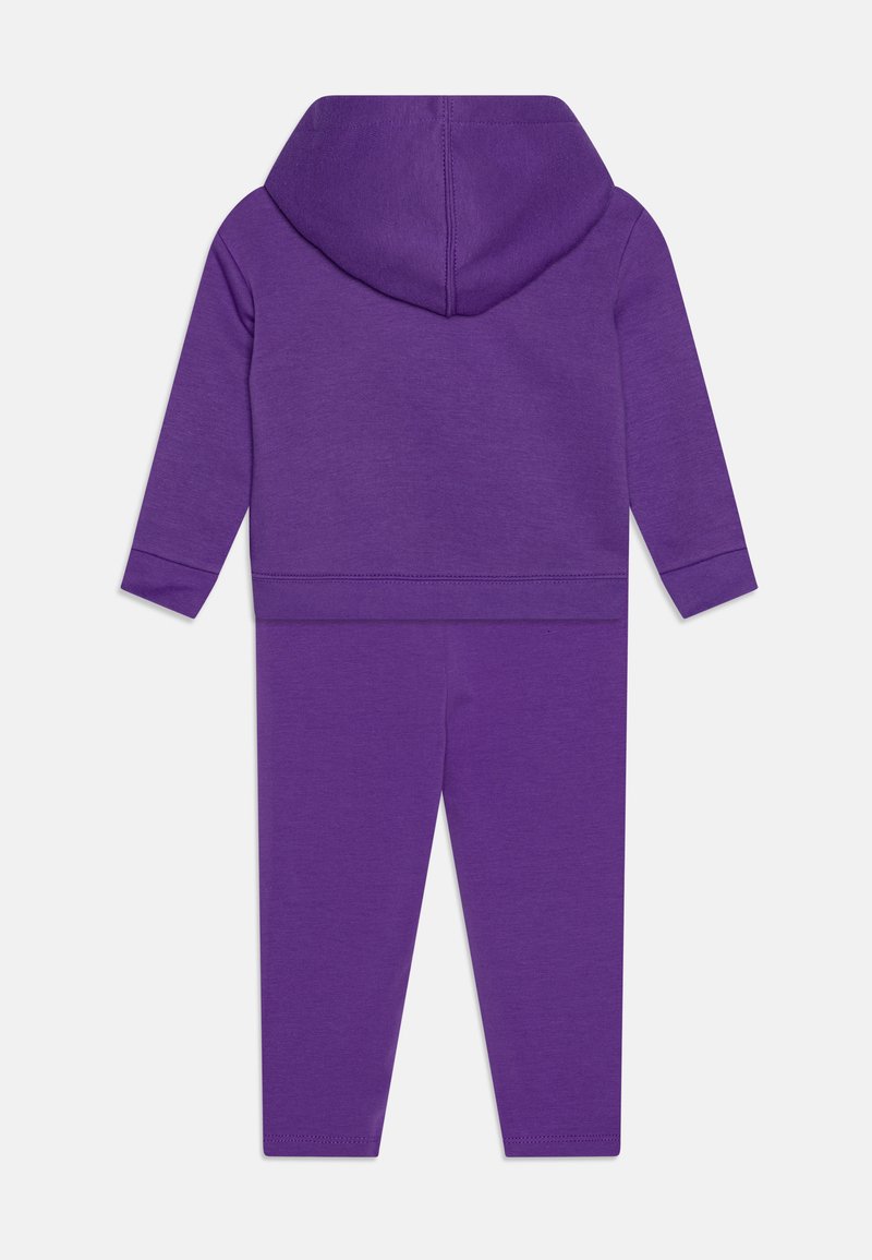 Felpa con cappuccio viola e pantaloni abbinati, realizzati in un materiale morbido. Presenta maniche lunghe, polsini elasticizzati e una texture liscia.