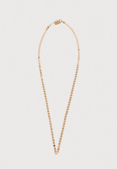 Złocony naszyjnik z małymi okrągłymi ogniwami o gładkiej fakturze oraz centralnym zdobieniem, przypominającym delikatny akcent kryształowy.