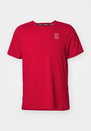 Camiseta roja de manga corta hecha de tejido texturizado. Presenta un logo blanco en el lado izquierdo del pecho y un cuello negro en contraste.