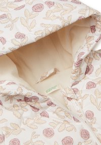 Giacca imbottita con un esterno bianco caratterizzato da un motivo floreale in rosa chiaro e beige, foderata in morbido pile color crema e con chiusura a zip.