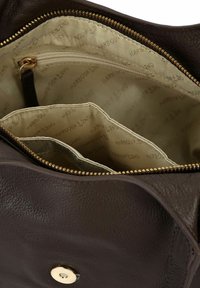 Interno di una borsa a mano in pelle marrone con fodera beige con marchio stampato, tasca con zip e più scomparti per l'organizzazione.