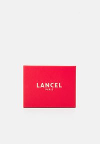 Vörös, fényes felületű téglalap alakú doboz, elöl középen fehér szöveggel: "LANCEL PARIS". Mintázat vagy díszítés nem látható.
