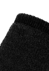 Schwarze gestrickte Socke mit strukturierter Oberfläche und geripptem Bündchen oben. Das Material wirkt warm und weich, geeignet für kaltes Wetter.