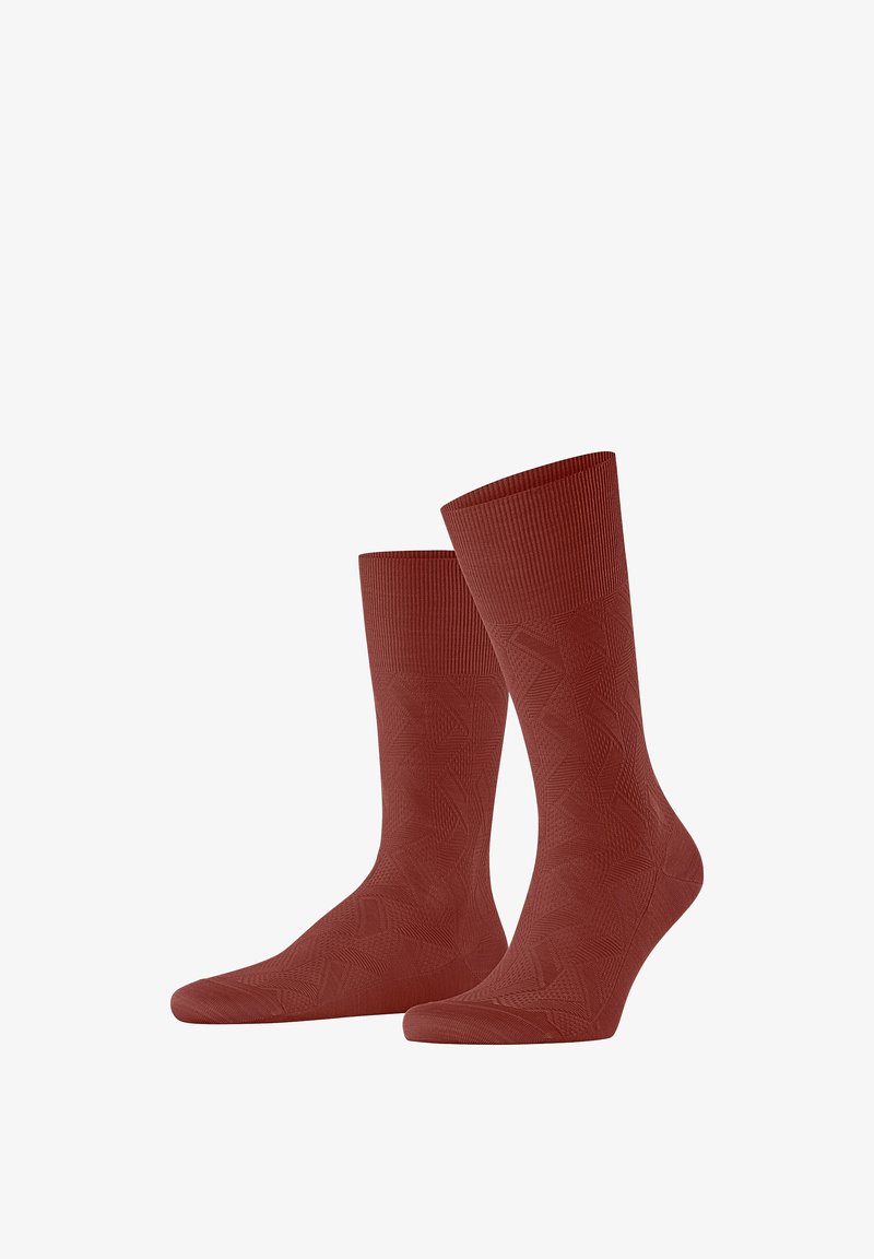 Des chaussettes rouges côtelées présentent un motif géométrique. Le design comprend une texture lisse et un ajustement serré au niveau du poignet pour plus de confort.