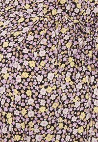 Tecido preto com um padrão floral pequeno em roxo, amarelo e branco, apresentando uma cintura franzida e um detalhe de laço para um visual ajustado.