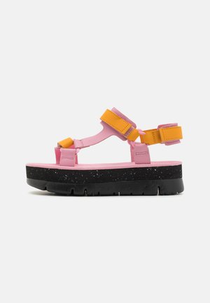 Rosa plattformssandaler med svart prickig sula. Har justerbara gula och rosa remmar för en säker passform, platt design med öppna tår.