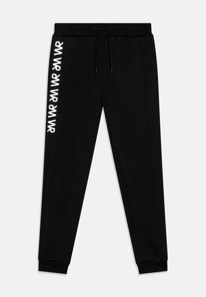 Zwarte joggingbroek met een trekkoord in de taille, taps toelopende pijpen en witte herhaalde branding langs de linkerkant. Gladde stof met elastische boorden.