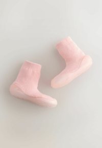 Jasnoróżowe, dziane buciki dla niemowląt z elastycznymi, teksturowanymi podeszwami, posiadające prążkowany mankiet i zaokrąglony przód.